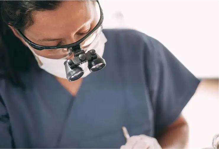 Zahnärztin bei einer endodontischen Behandlung mit Vergrößerungslupe in der Zahnarztpraxis Sandhofpassage Bad Soden – präzise Wurzelkanalbehandlung für Zahnerhaltung