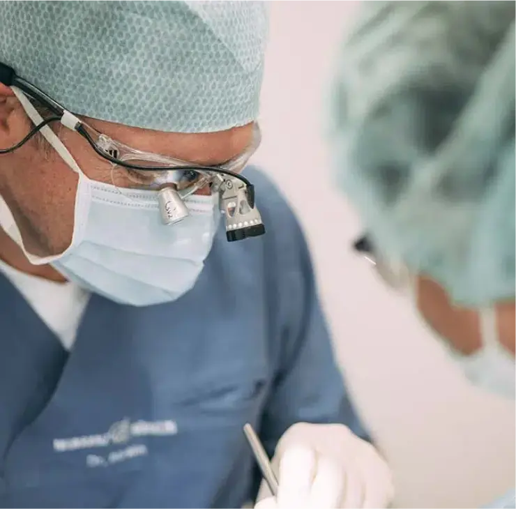 Zahnarzt bei einer endodontischen Behandlung mit Vergrößerungslupe in der Zahnarztpraxis Sandhofpassage Bad Soden – präzise Wurzelkanalbehandlung für optimale Zahnerhaltung