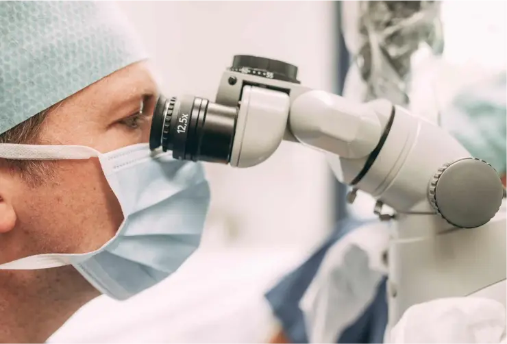 Zahnarzt bei einer endodontischen Behandlung unter dem Mikroskop in der Zahnarztpraxis Sandhofpassage Bad Soden – präzise Wurzelkanalbehandlung mit modernster Technologie