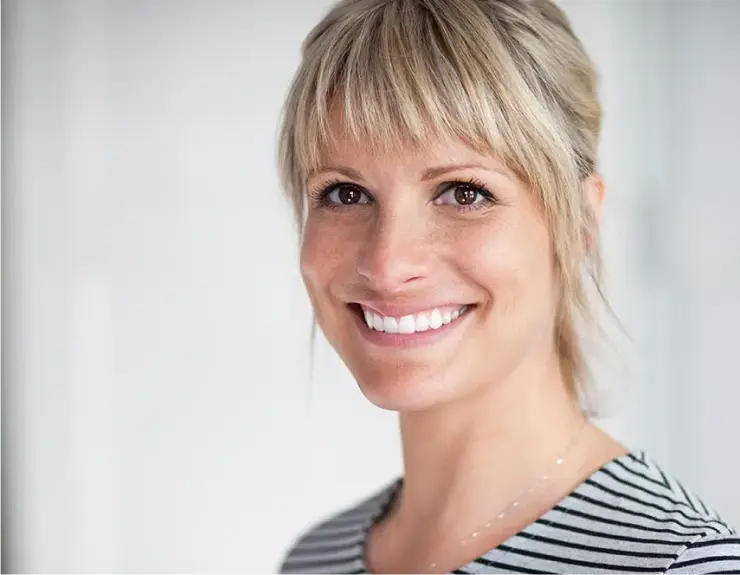 Porträt einer lächelnden Frau mit weißen, geraden Zähnen. Die Nahaufnahme betont das Ergebnis einer ästhetischen Zahnbehandlung in Bad Soden, das ein gesundes und schönes Lächeln zeigt.