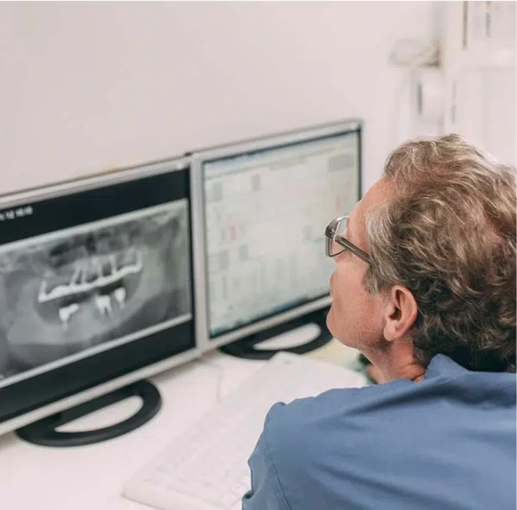 Zahnarzt in Bad Soden betrachtet digitale Röntgenaufnahmen am Computer – präzise Analyse für optimale Behandlungsplanung