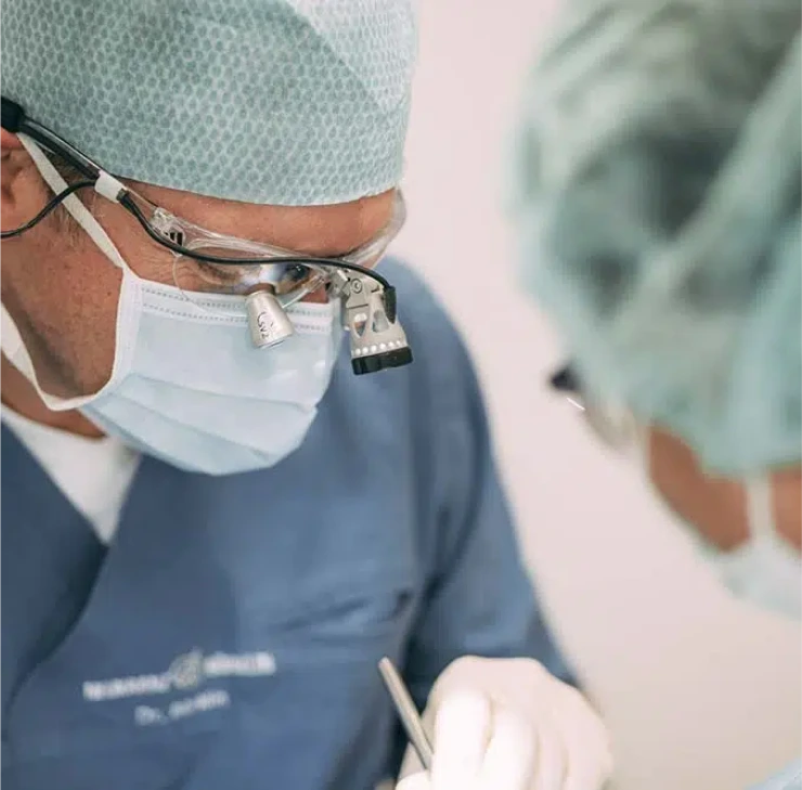 Zahnarzt in Bad Soden führt einen präzisen chirurgischen Eingriff mit Lupenbrille und moderner Technik durch