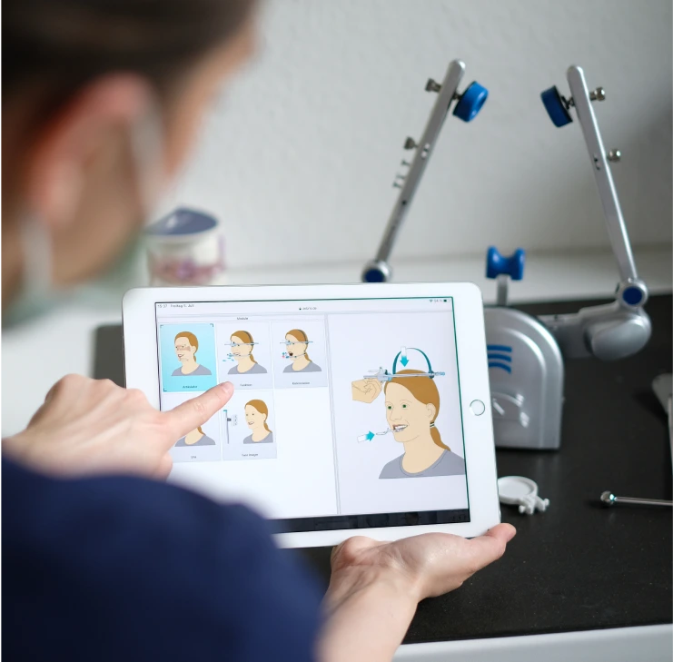 Zahnarzt in Bad Soden demonstriert auf einem Tablet die Funktionsweise einer kieferorthopädischen Behandlung – digitale Patientenaufklärung